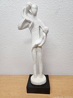 Front view of the entire statue showing the dad figure holding children and the black base.