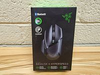 Front view of the original retail box showing the Razer Basilisk X Hyperspeed gaming mouse, highlighting Bluetooth and 5G wireless features.