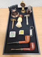 Full tray with all items including pipes, razors, brush, bell, bust figurine, and keychains