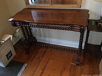 Front view of entire hall table showing tabletop shape and spiral-turned support bars