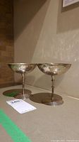 Pair of sterling silver chalices standing side by side on surface