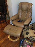 Overview of chair and ottoman with vinyl records on hardwood floor