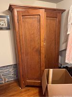 Closed exterior front view of the wardrobe showing two paneled doors and top molding