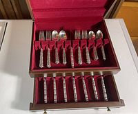 Flatware neatly stored in the handcrafted wooden silverware box with red velvet lining and organizing slots.