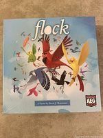 Front of the Flock board game box showing colorful bird illustrations and game title