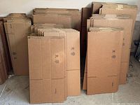 Flattened Uline cardboard moving boxes stacked by size