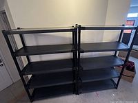 Two black shelving units pictured side by side inside a room, each with five shelves; shelves appear sturdy and in excellent condition.
