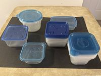 Top view of assorted Ziploc containers showing various sizes and lid colors, arranged on black background.