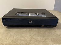 Front of Sony BDP-S500 Blu-Ray disc player closed, black device showing front panel with Sony and Blu-Ray branding.