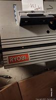 Close-up of Ryobi logo on the planer metal body.