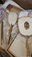 Full set showing hand mirror, brush, and comb in original box with plastic wrapping