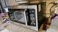 Toshiba stainless steel microwave with digital keypad, clock display showing 9:21