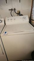 Photo of full Kenmore 600 Series heavy duty washer showing white top-loading design with closed lid and control panel with multiple control knobs.
