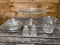 Photo showing all five crystal items on wooden surface: cake plate, salt and pepper shakers, juicer, and small pitcher