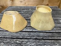 Pair of ceramic jelly moulds shown from the bottom side on a wooden surface, one smaller and one larger.