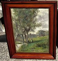 Frontal view of the oil painting and frame showing the landscape and two figures beside a pond with trees in dense foliage. Walnut frame is polished with visible grain and slight age wear.