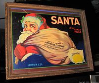 Frontal photo of framed vintage Santa Claus Sunkist lemons advertising poster showing full artwork and frame.