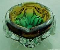 Clear frontal view showing the tri-colour design of green, amber, and clear glass with an organic rounded ruffled shape.