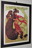 Full view of the framed art poster showing the three-headed dragon and muscular man in red with 'UNTERWELT' text at top.