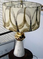 Full view of the lamp showing the base and original parchment shade with distinctive wavy brushstroke design.