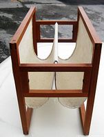 Side view showing V-shaped linen compartments suspended between teak side panels