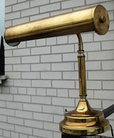 Side view showing the polished brass cylindrical twin-light shade and detailed stem.
