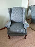 Front view of upholstered wingback recliner in light teal fabric