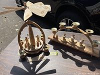 4 candle wooden mill with a propeller needing blade repair, carved trees and figures on the base