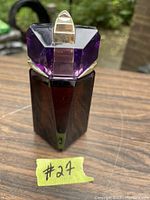 Front view of purple geometric Alien perfume bottle with gold accents, showing the design and partial liquid inside.