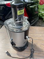 Full view of Magic Bullet Juice Bullet electric juicer showing feeding chute, transparent juice container, and power cord.