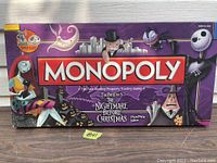 Closed packaging box of Monopoly The Nightmare Before Christmas Collector's Edition with vibrant character illustrations and game title.