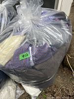Plastic bag filled with folded ladies clothes including striped shirt visible through bag