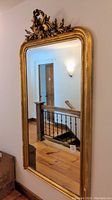 Full view of large giltwood mirror hanging on wall
