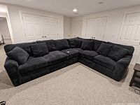 Wide shot of entire L-shaped sectional sofa in basement room