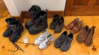 Full view of all 7 pairs of men's footwear laid out showing variety of brands and styles including boots, shoes, slippers.
