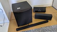 Samsung HW-J355 sound bar with additional speakers and subwoofer arranged on floor