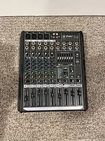 Top view of Mackie ProFX8V2 mixer showing 8 channels, knobs, faders, and input/output ports