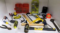 Photo showing a variety of the tools including drill bit sets, screwdrivers, mallets, hacksaw, tape measure, and pliers.