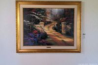 Framed Thomas Kinkade 'Spring Gate' artwork hung on wall, showing full image and frame.
