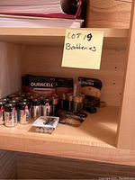 Shelf with various battery types including Duracell and Energizer, some in packaging and some loose