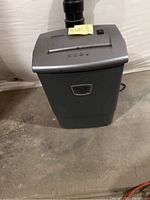 Full view of silver Fellowes paper shredder showing general shape and waste bin.