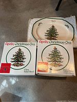 Glass salad bowl and round deep casserole in their original boxes next to the serving platter with Christmas tree design.
