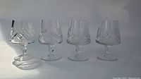 Four Pinwheel crystal brandy snifters arranged side by side showing detailed cut patterns.