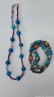 Full view of necklace and watch side by side showing the turquoise beads and watch face.