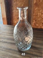 Clear glass bottle showing diamond etched patterns and shape