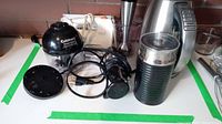 Photo showing electric kettle, Cuisinart Smart Stick parts including chopper attachment and hand blender base, power cords, and a plastic base or stand for the blender.