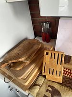 Wooden cutting boards and knife block displayed on kitchen counter with salt and pepper mills in background.
