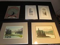 Five artworks displayed: two large framed Jasper Alberta landscape prints, one Indian peacock painted and foiled on glass unframed, and two framed Quebec City etchings.