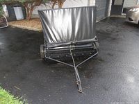 Sweeper folded for storage with fabric hamper and hitch