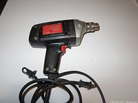 Single corded electric drill with black and silver body and attached power cord
